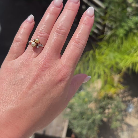 High-definition video capturing the soft iridescent glow of the natural pearl, the fiery brilliance of the old-cut diamond, and the elegant romantic curvature of the antique 1900s Belle Époque Toi et Moi ring in motion.