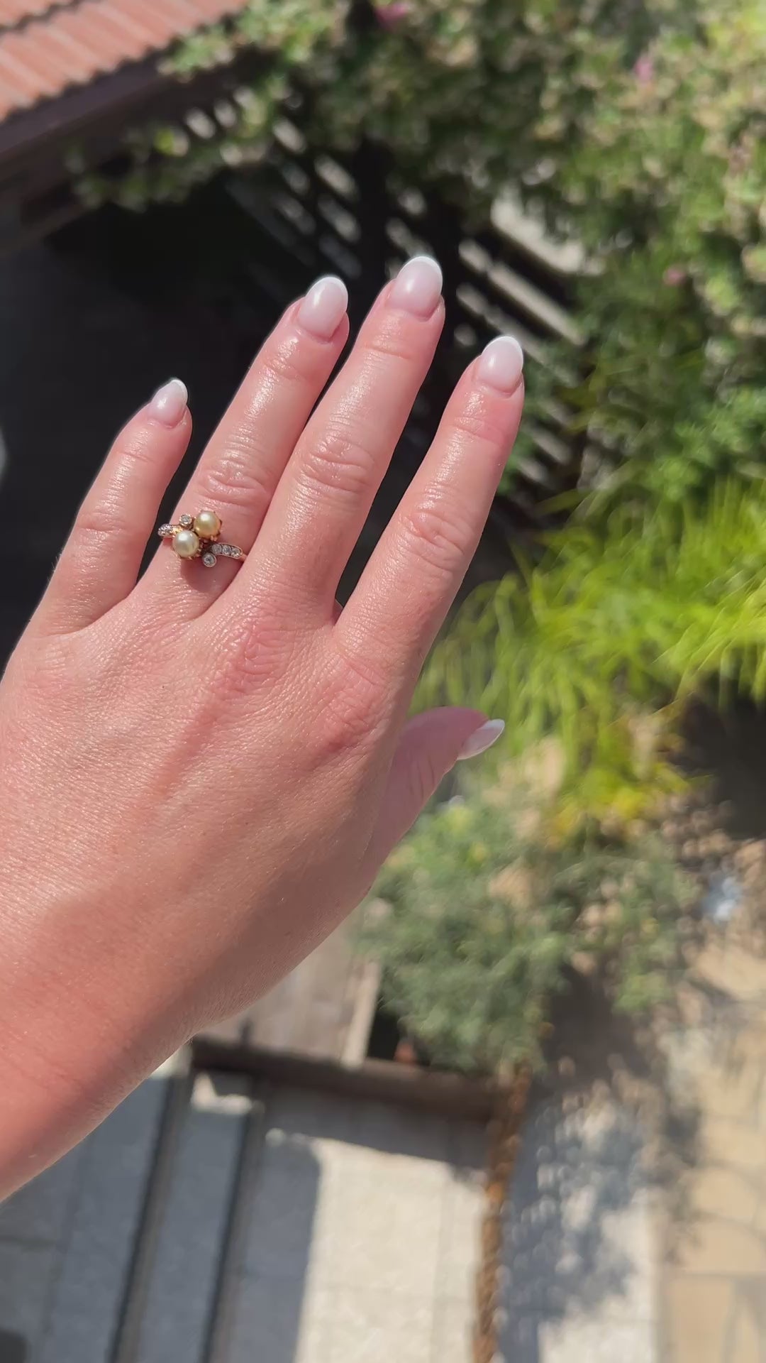 High-definition video capturing the soft iridescent glow of the natural pearl, the fiery brilliance of the old-cut diamond, and the elegant romantic curvature of the antique 1900s Belle Époque Toi et Moi ring in motion.
