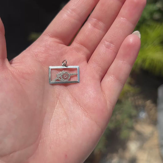 High-definition video capturing the intense brilliance, fiery diamond sparkle, and vivid ruby contrast of the antique Art Deco platinum cannon military pendant in motion.
