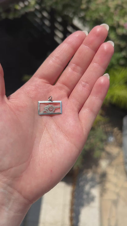 High-definition video capturing the intense brilliance, fiery diamond sparkle, and vivid ruby contrast of the antique Art Deco platinum cannon military pendant in motion.