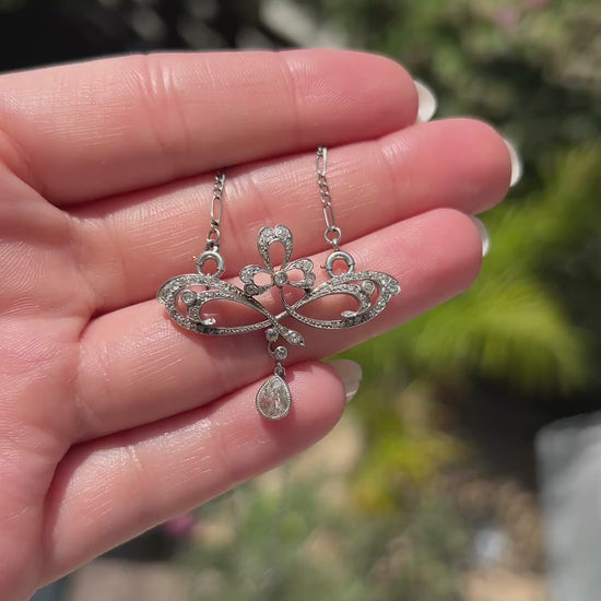 High-definition video capturing the fluid, organic movement of the 0.4-carat pear-cut diamond drop, the fiery brilliance of the accent stones, and the delicate platinum craftsmanship of the circa 1910 Art Nouveau pendant necklace in motion.