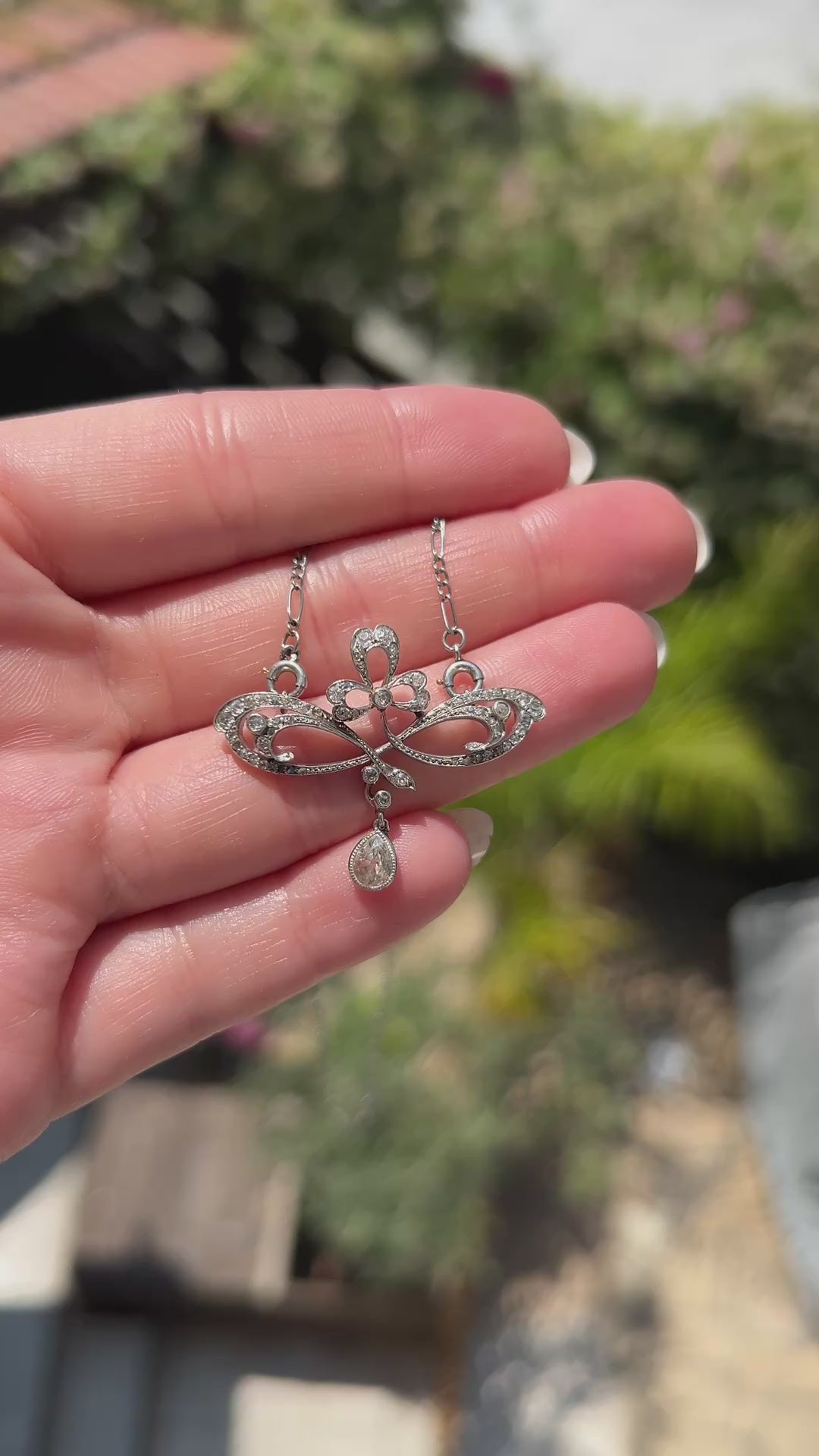 High-definition video capturing the fluid, organic movement of the 0.4-carat pear-cut diamond drop, the fiery brilliance of the accent stones, and the delicate platinum craftsmanship of the circa 1910 Art Nouveau pendant necklace in motion.