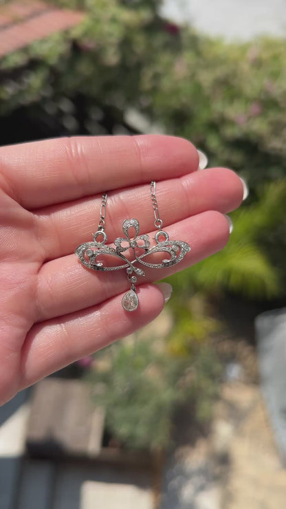 High-definition video capturing the fluid, organic movement of the 0.4-carat pear-cut diamond drop, the fiery brilliance of the accent stones, and the delicate platinum craftsmanship of the circa 1910 Art Nouveau pendant necklace in motion.
