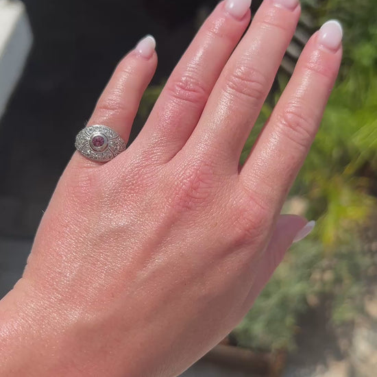 High-definition video capturing the vibrant pink hue of the tourmaline, the fiery brilliance of the accent diamonds, and the intricate geometric openwork of the 1920 Art Deco platinum ring in motion.
