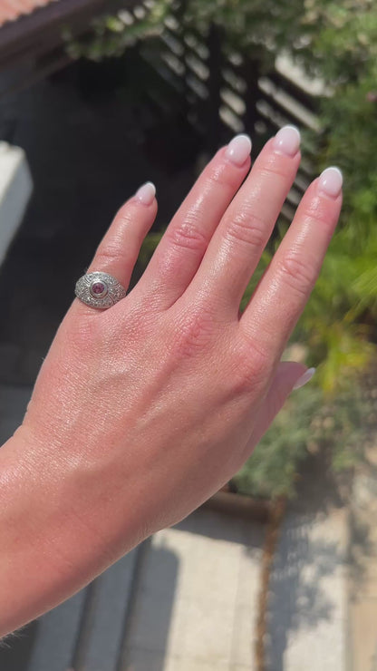 High-definition video capturing the vibrant pink hue of the tourmaline, the fiery brilliance of the accent diamonds, and the intricate geometric openwork of the 1920 Art Deco platinum ring in motion.