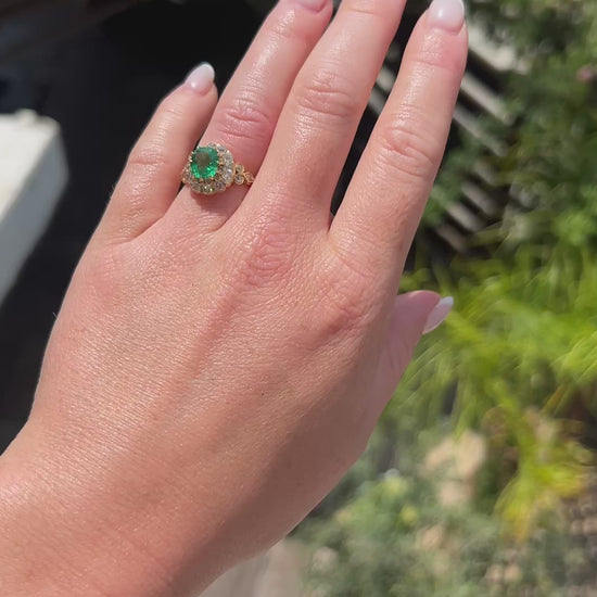 High-definition video capturing the intense green glow of the natural antique emerald, the fiery brilliance of the double diamond halo, and the regal presence of the Victorian era cocktail ring in motion.
