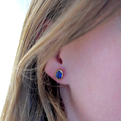 Macro shot of a 1 carat oval natural blue sapphire in a 18k gold four-prong setting