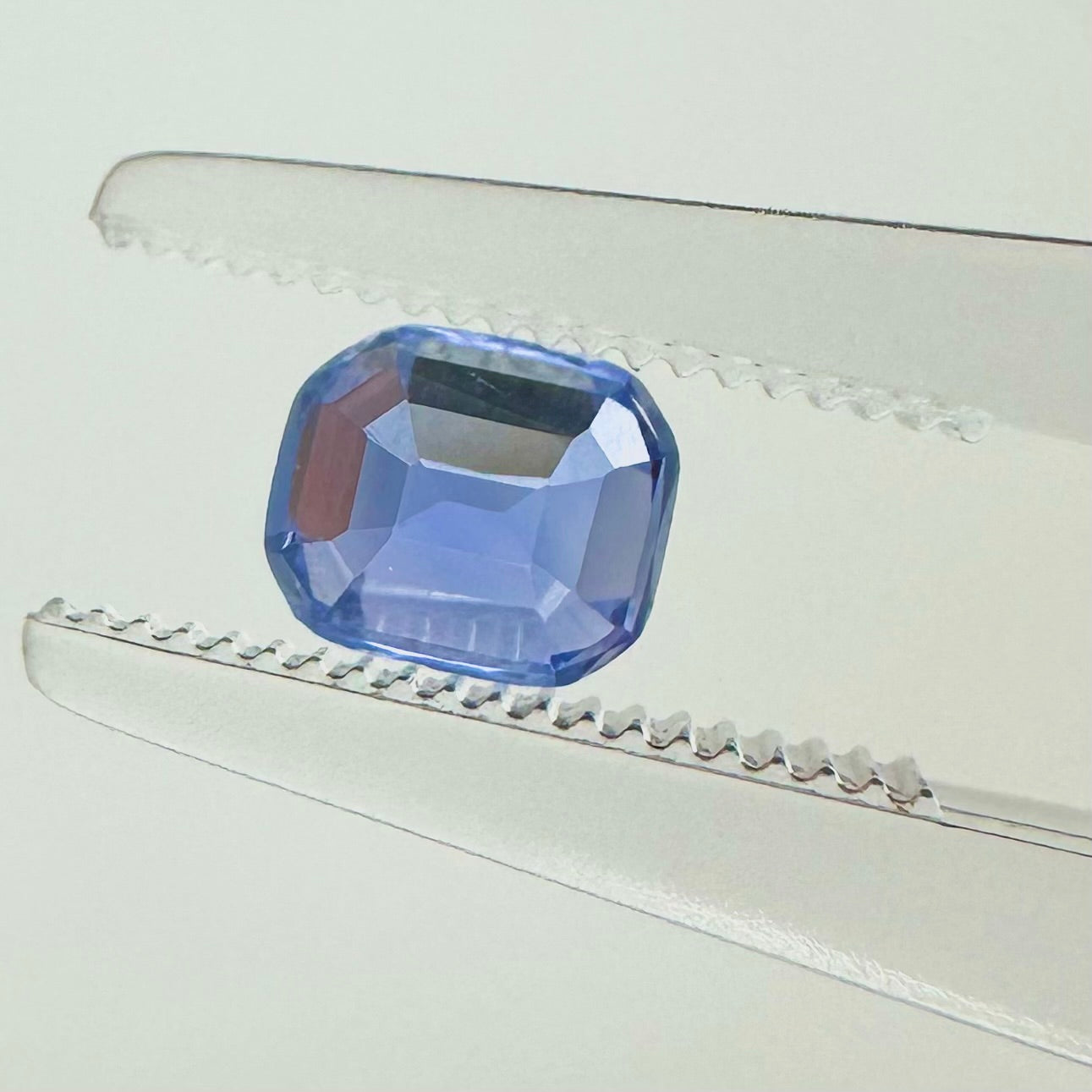 Reverse back view of the natural emerald cut blue sapphire from Ceylon demonstrating its excellent clarity, open step facets, and lack of heat treatment.