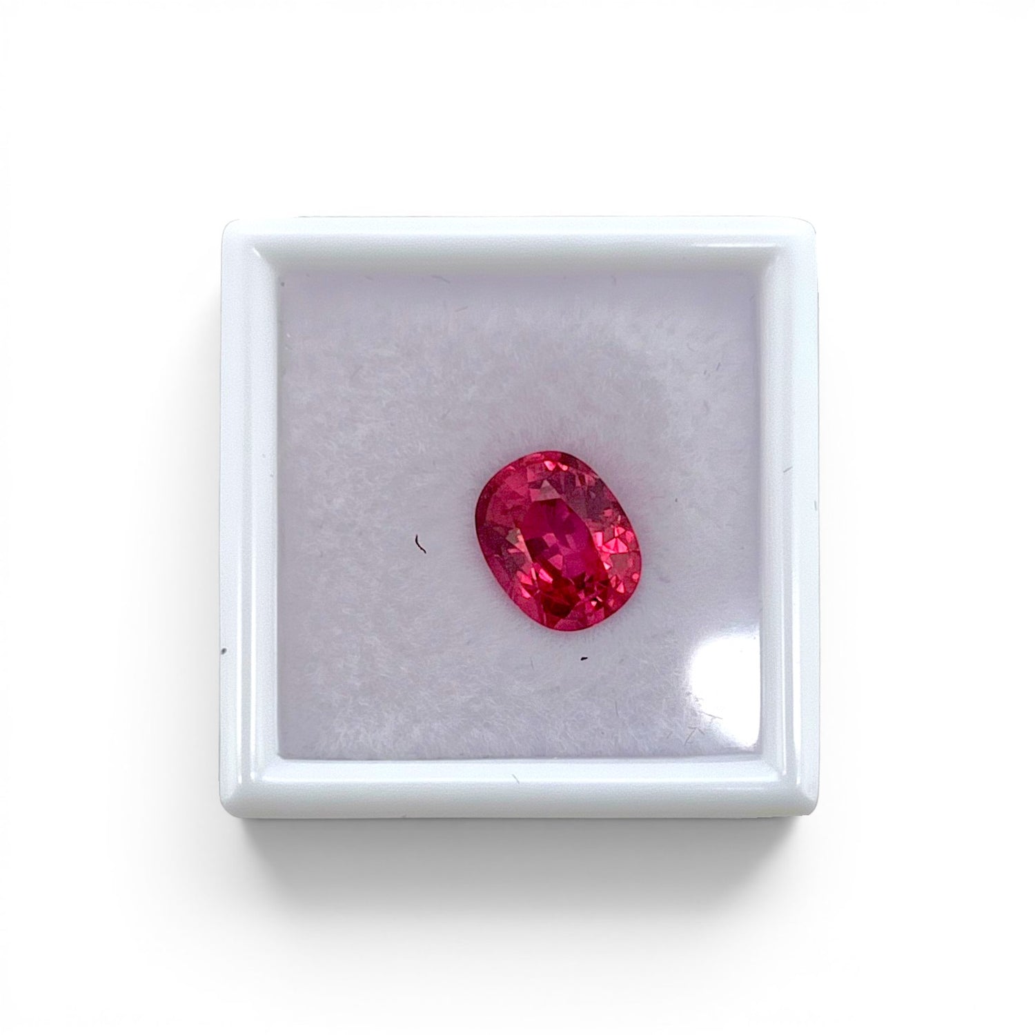 Loose 2.40 carat unheated electric pink orange spinel gemstone from Vietnam displayed inside a luxury presentation gem box by Antique Jewelry Finds.