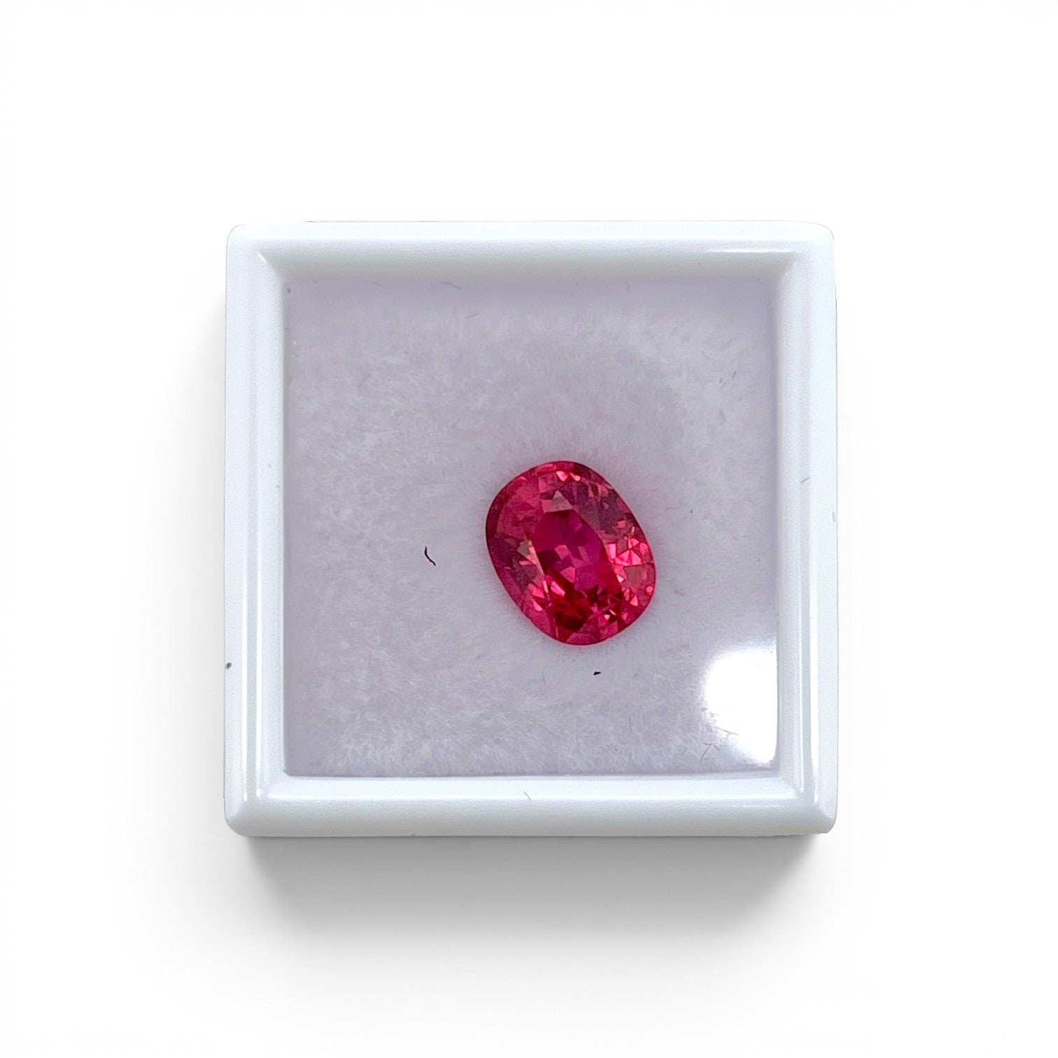 Loose 2.40 carat unheated electric pink orange spinel gemstone from Vietnam displayed inside a luxury presentation gem box by Antique Jewelry Finds.