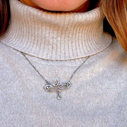 Art Nouveau platinum diamond necklace worn on a neck for scale and elegance