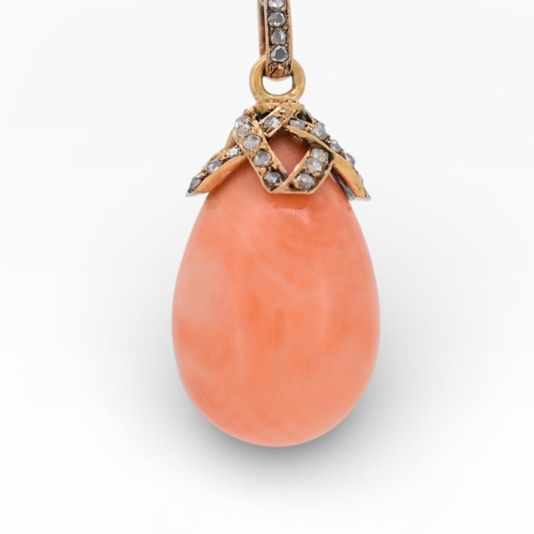 Close-up of natural salmon-pink coral drop on an antique 1900s gold pendant