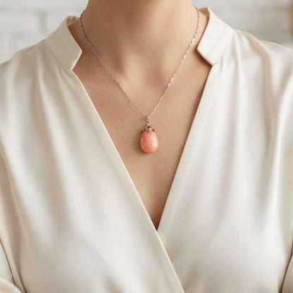 Victorian coral and diamond pendant held in hand for scale and color reference