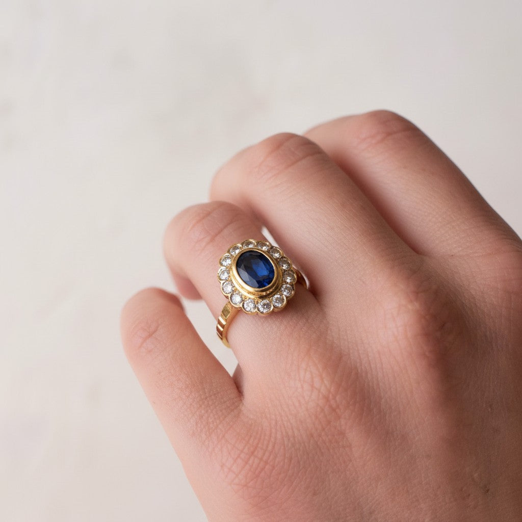 Close-up view of the natural sapphire halo ring on a finger, showcasing its striking scale and royal sparkle in daylight.