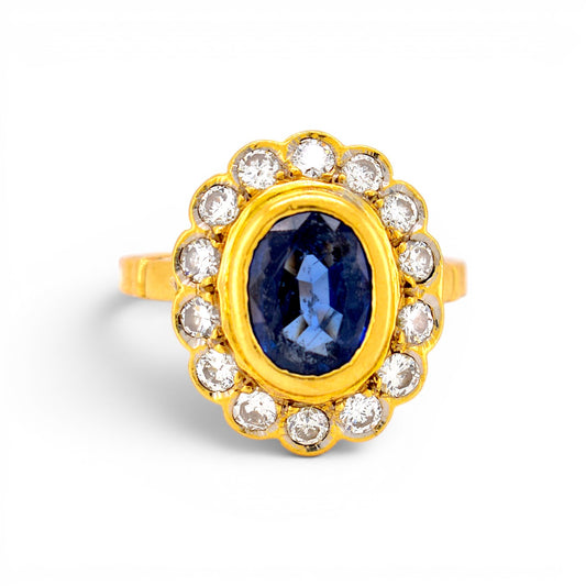 Vintage 1980s French 18k gold marguerite cluster ring with a 2ct blue sapphire and brilliant diamond halo by Antique Jewelry Finds.