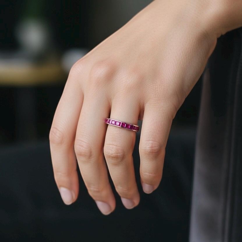 Vintage invisible-set ruby eternity statement ring worn on a hand for scale and color vividness