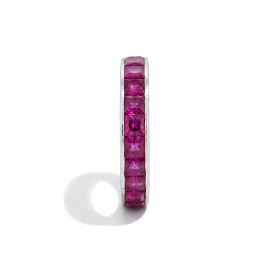 Detailed macro shot of princess-cut rubies in a seamless mystery setting without prongs