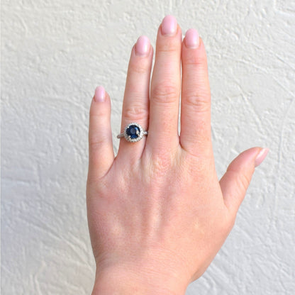 Large 12x12mm double diamond halo sapphire statement ring worn on a hand