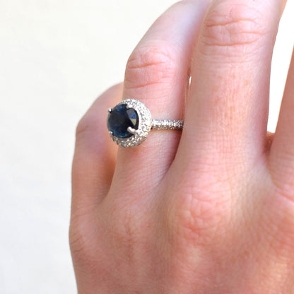 Macro shot of 3 carat natural blue sapphire centered in a geometric double halo setting